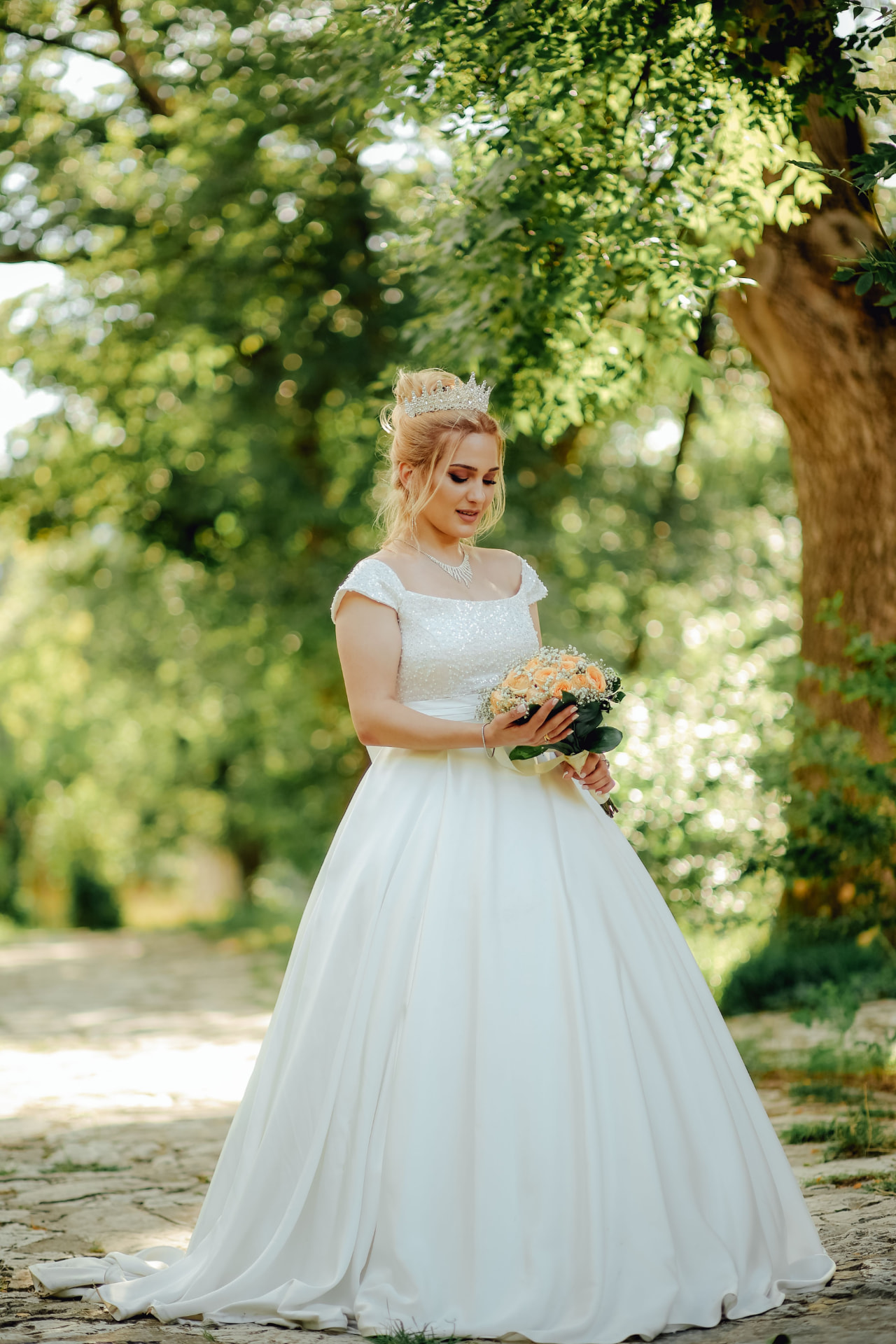 Bride with bouquet under a tree