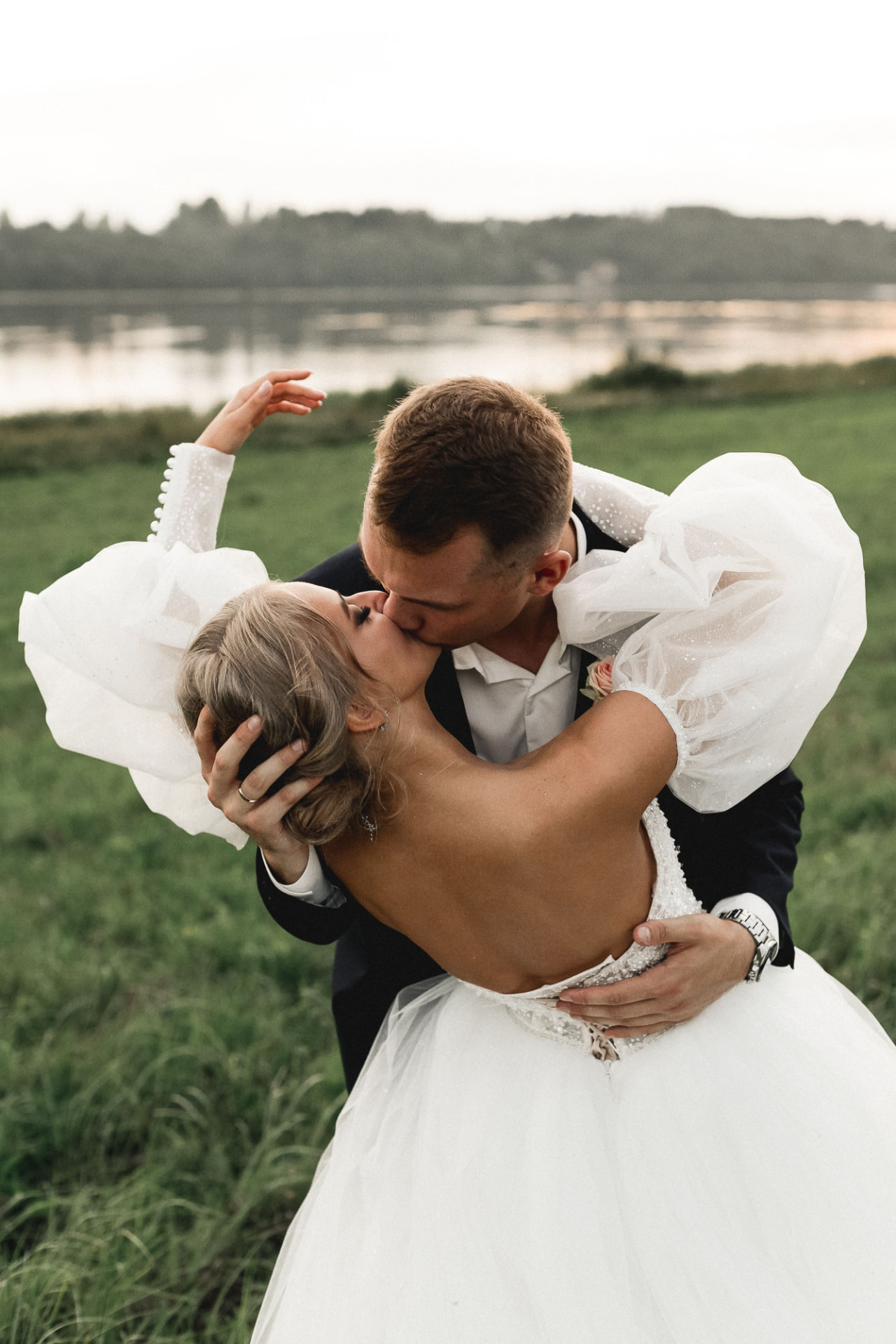 Couple kissing by the lake at sunset