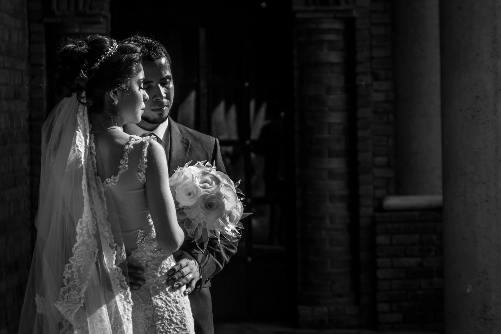 Bride and groom in dramatic light, black and white